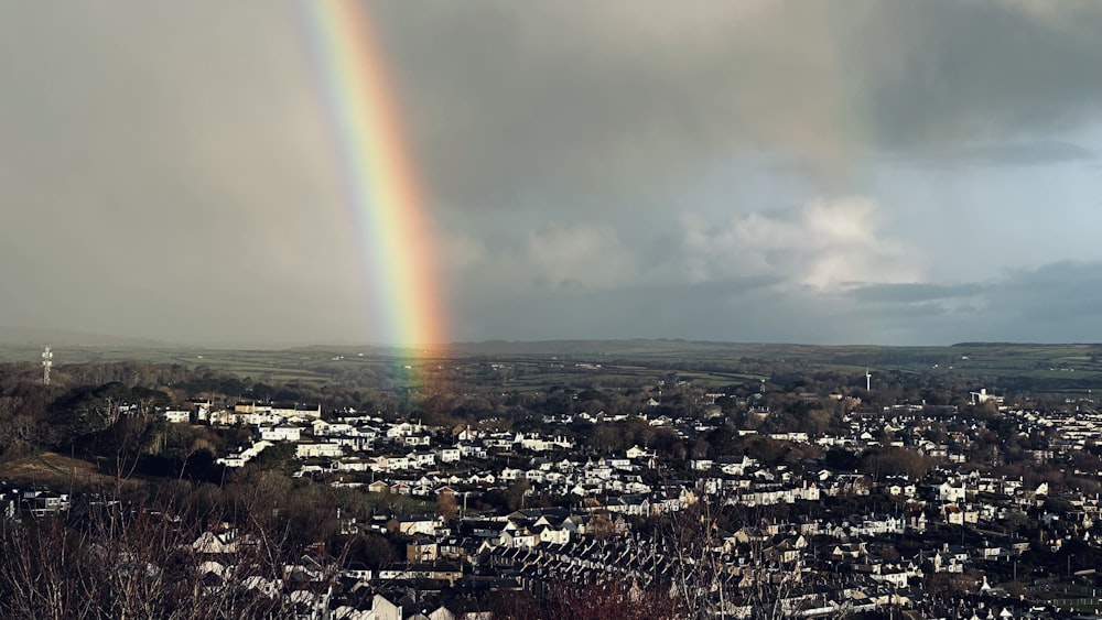 a rainbow shines in the sky over a city