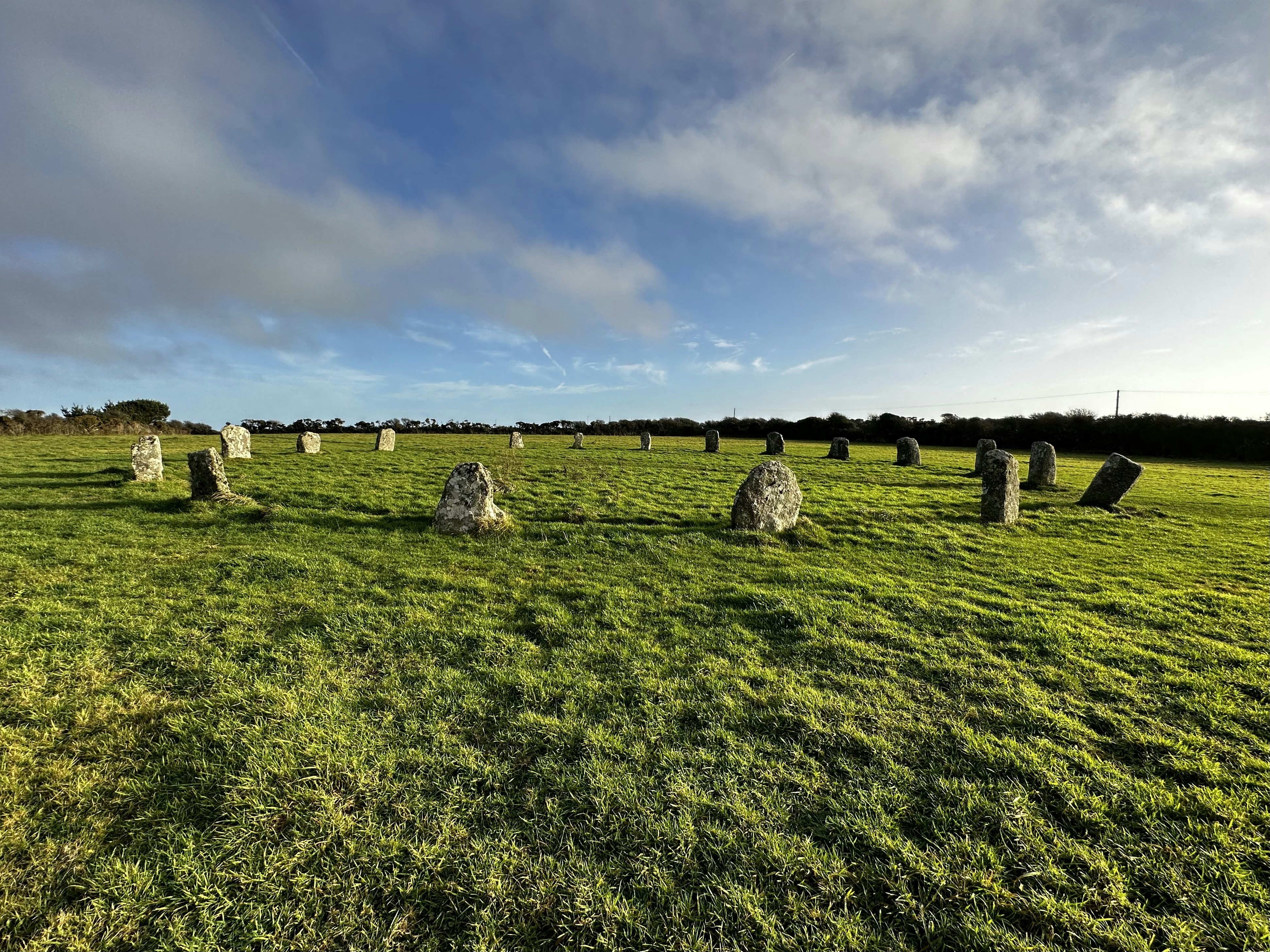 a grassy field with large rocks in the middle of it, 