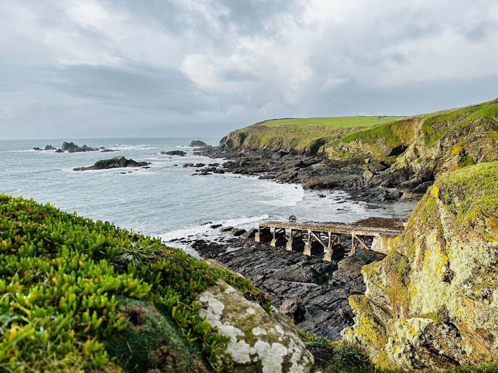 a view of a rocky coastline with a bridge in the foreground