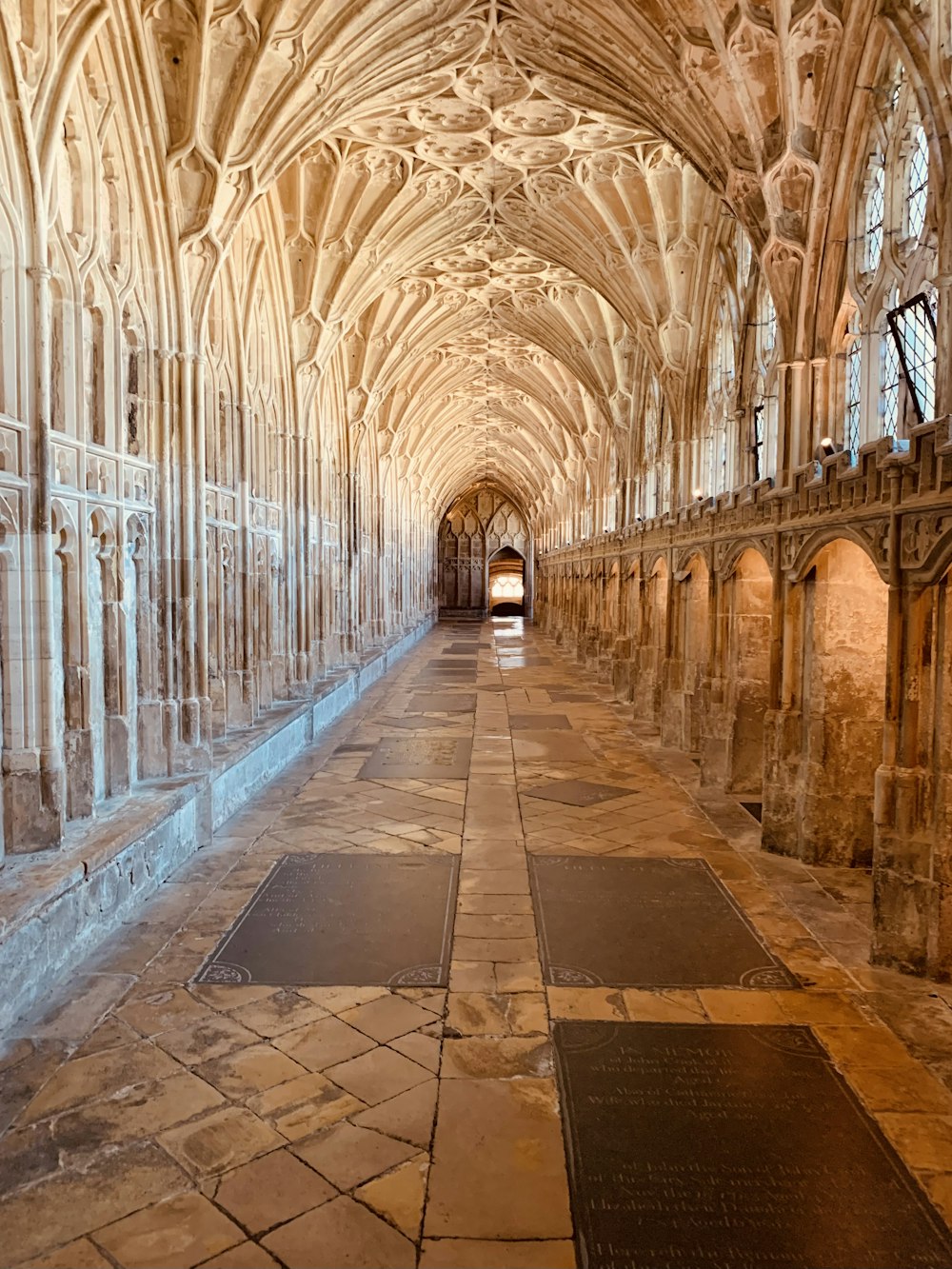 un lungo corridoio con pavimenti in pietra e archi