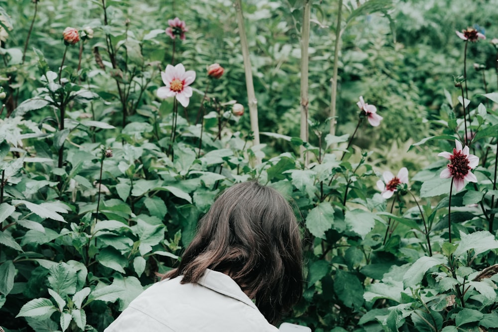 Une femme debout dans un champ de fleurs