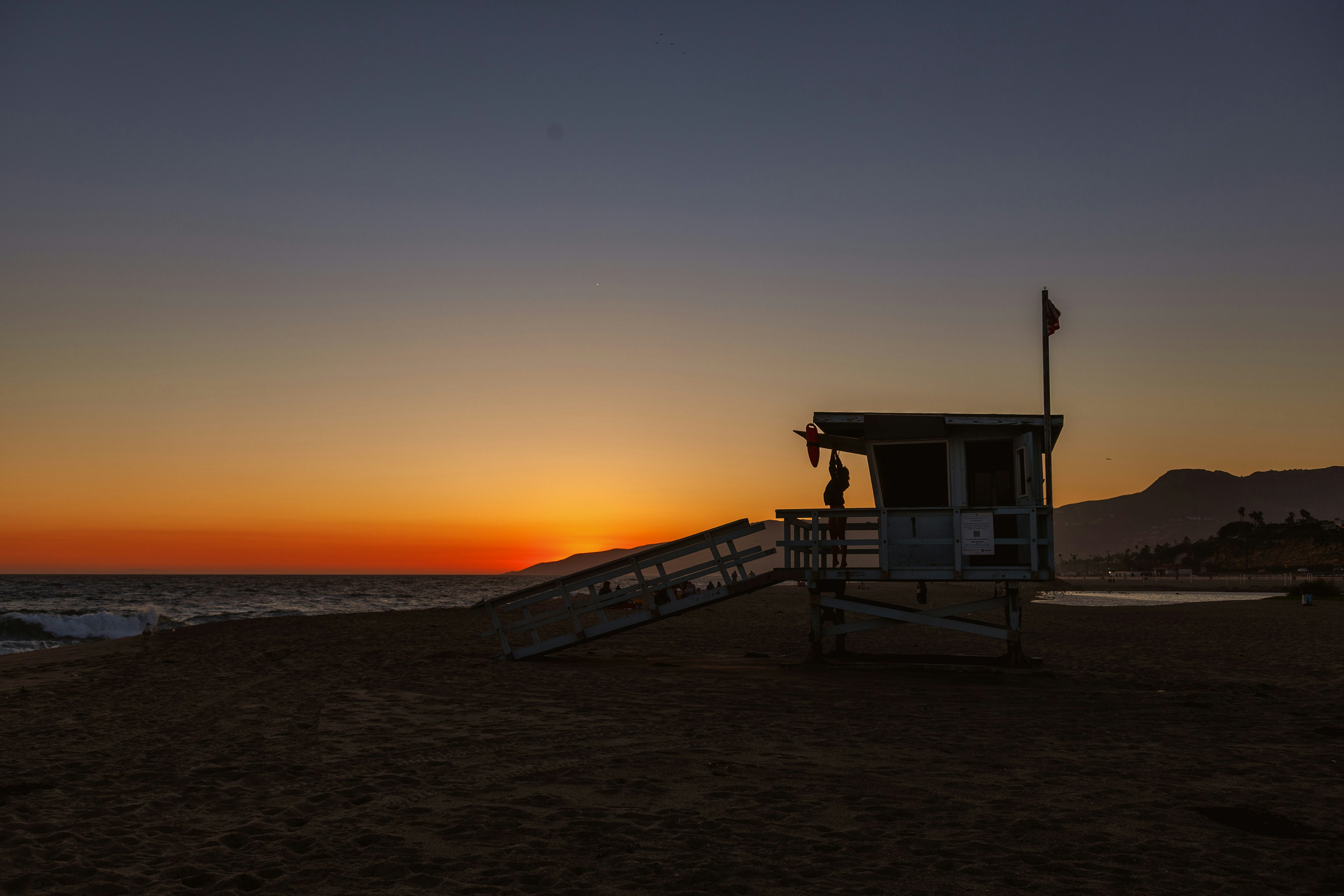 a lifeguard tower sitting on top of a sandy beach