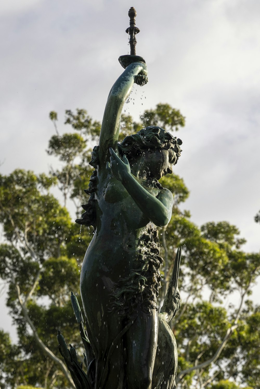 uma estátua de uma mulher segurando uma bica d'água