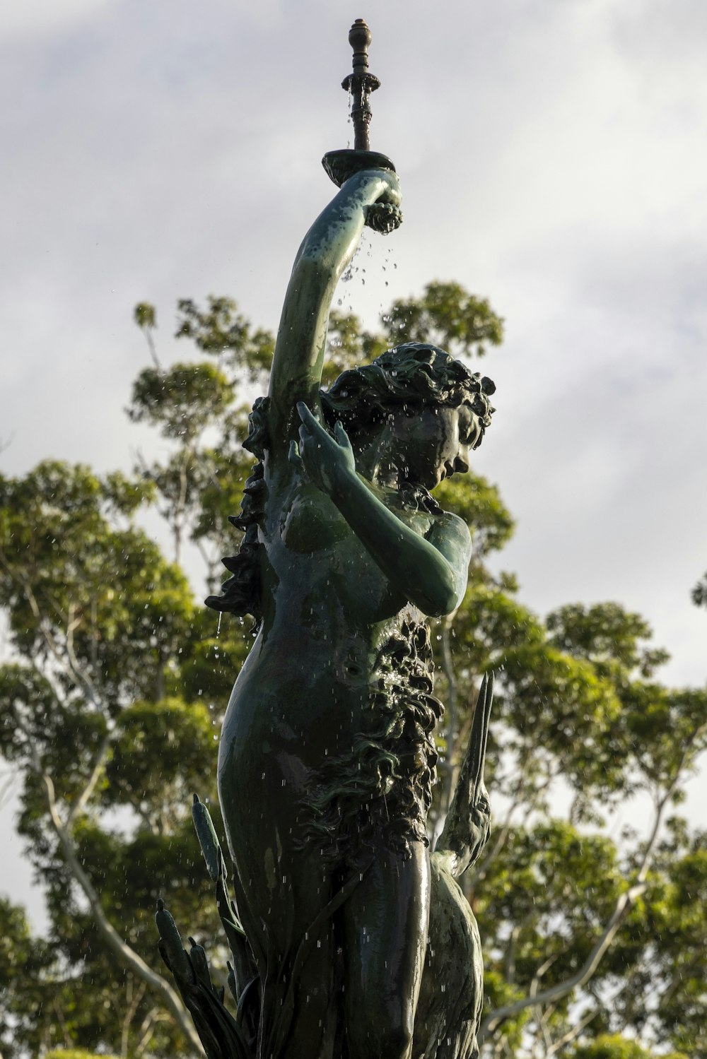 a statue of a woman holding a water spout