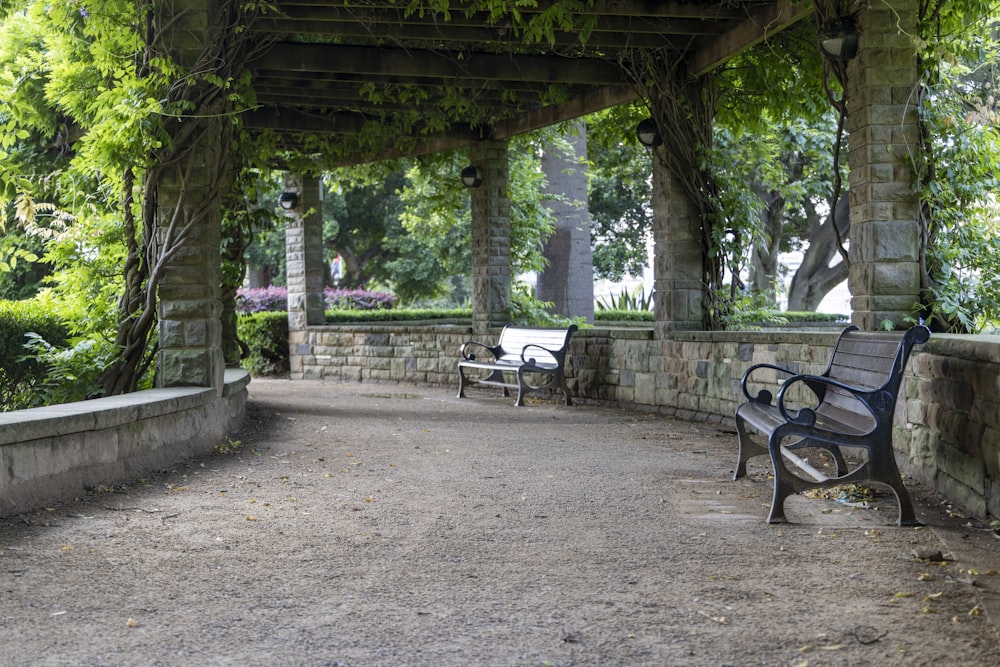 a couple of benches sitting under a covered walkway