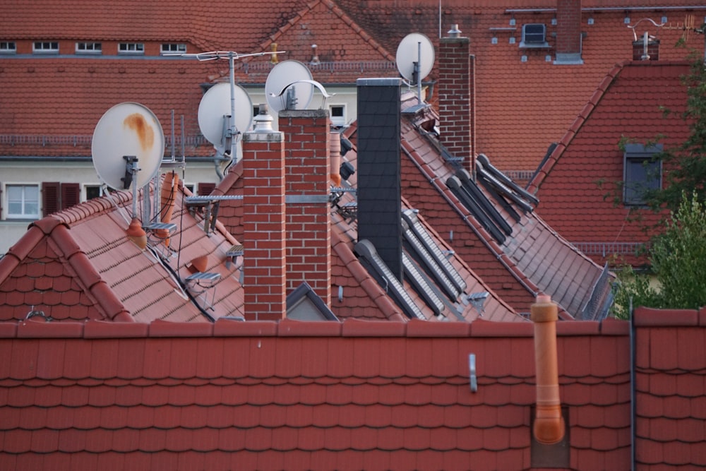 a row of rooftops with a red brick building in the background