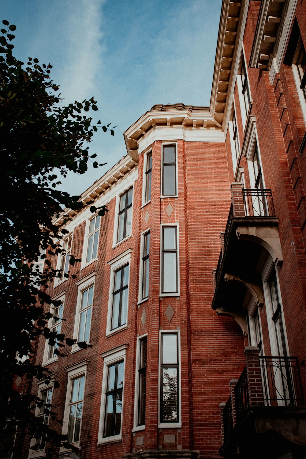 a tall red brick building with windows and balconies