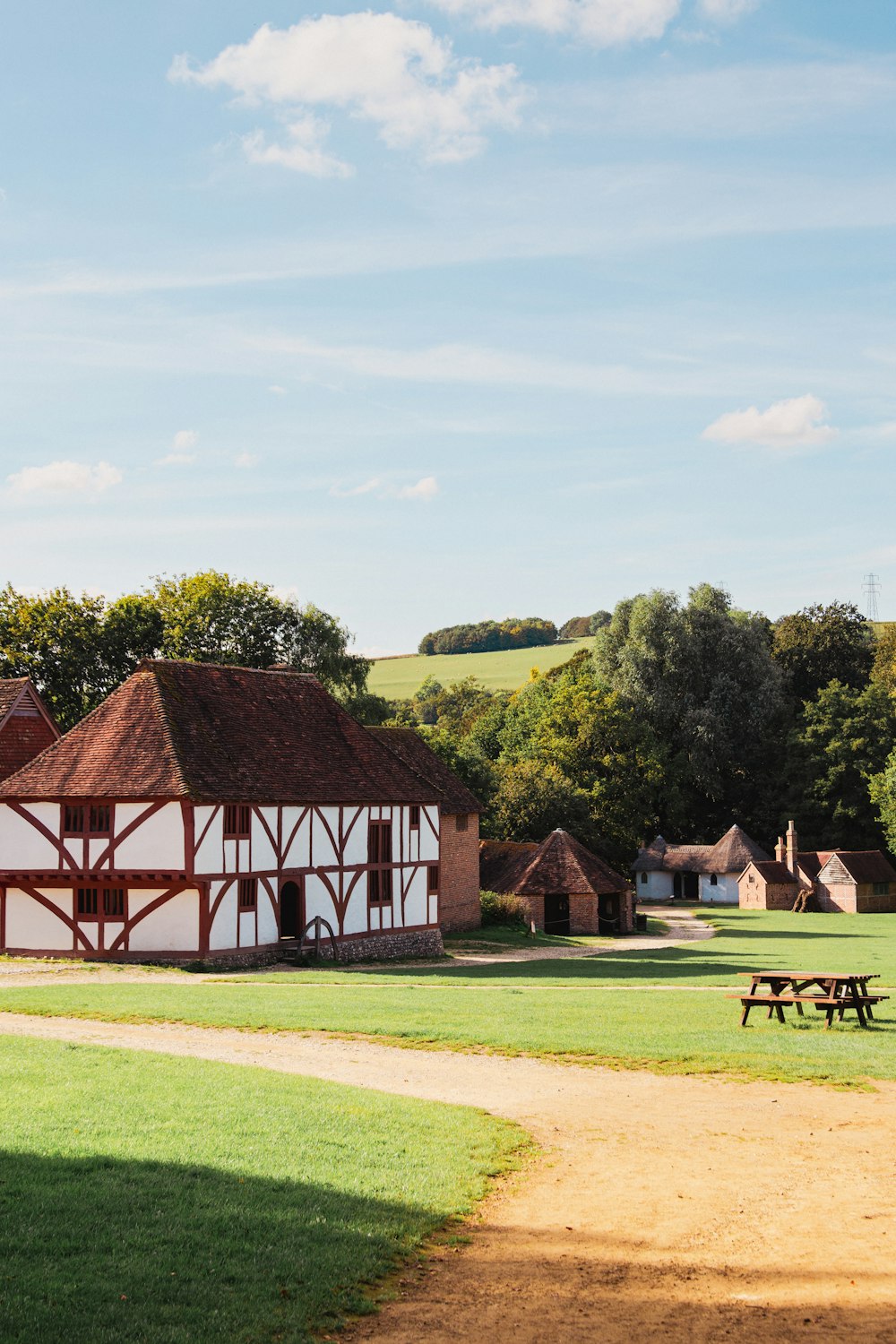 a large white and brown building with a picnic table in front of it