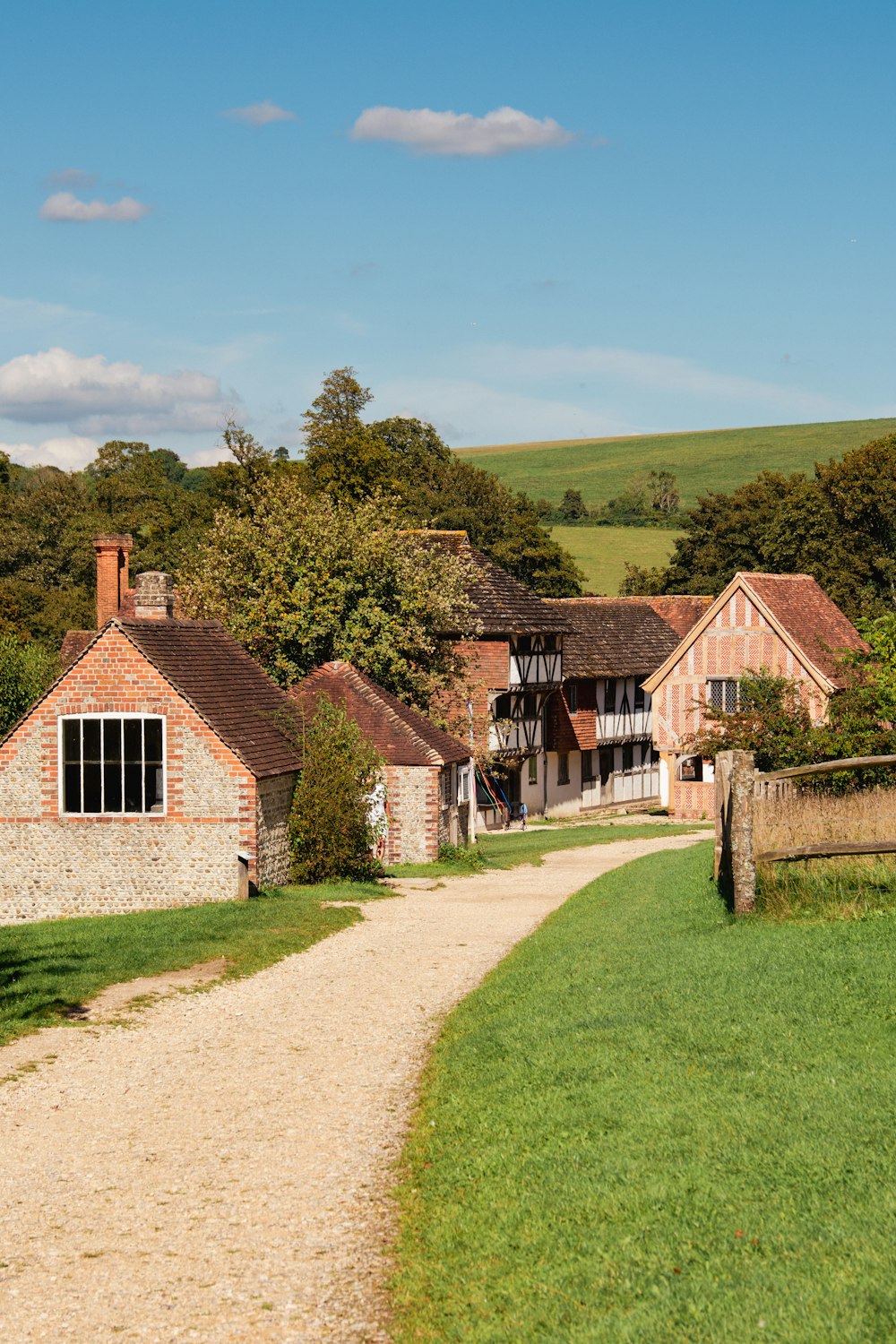 a dirt path leading to a house in the countryside