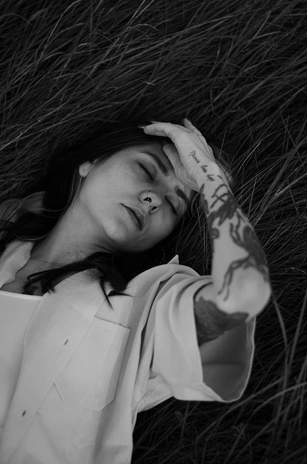 a woman laying in the grass with her eyes closed