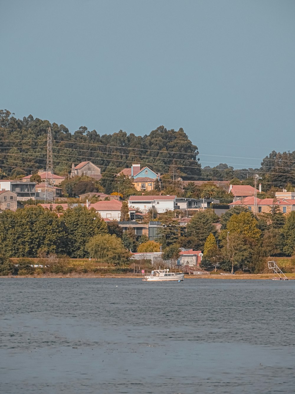 a large body of water with houses on a hill in the background