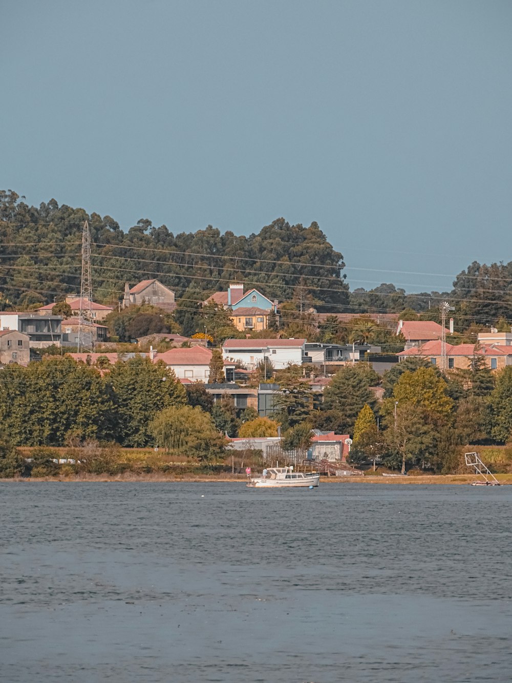 ein großes Gewässer mit Häusern auf einem Hügel im Hintergrund