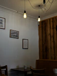 A cozy coffee shop corner with a customer enjoying Tarshostha coffee surrounded by rustic decor