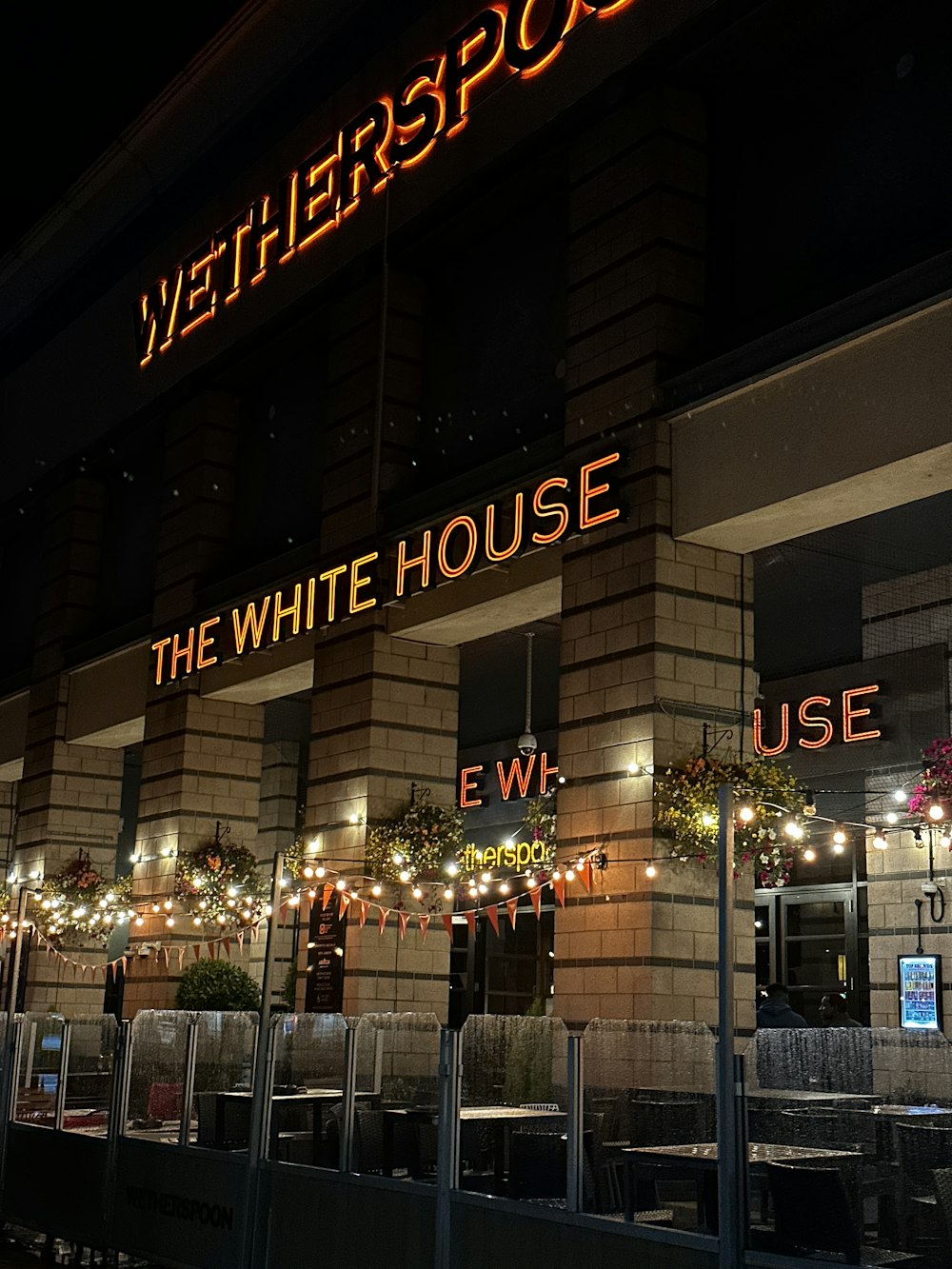 the front of a restaurant at night with a neon sign