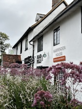 a white building with purple flowers in front of it