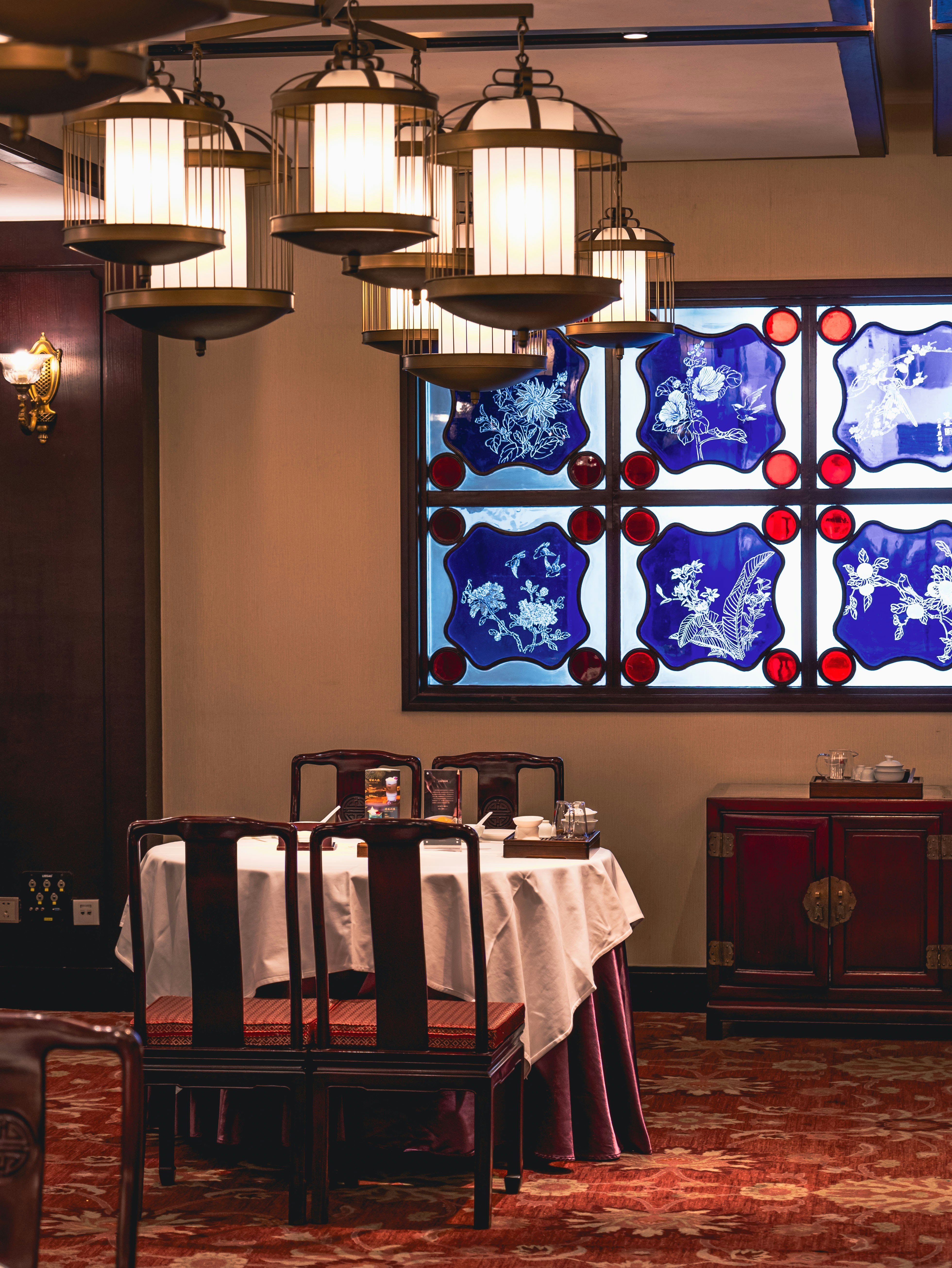 a dining room with a large stained glass window