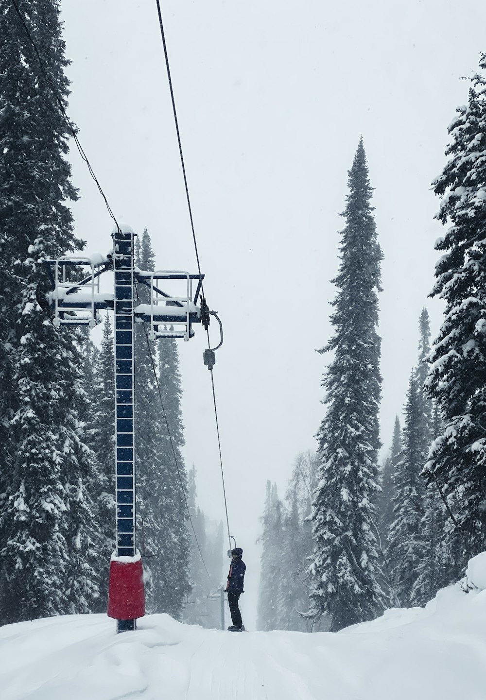 雪の日にスキーリフトに乗る人
