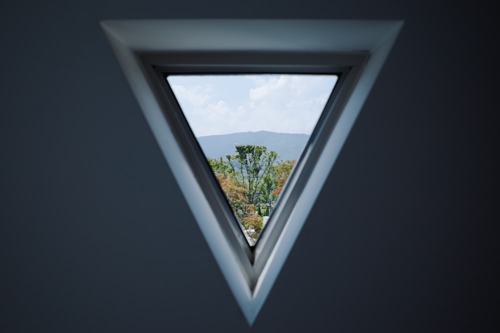 a triangle shaped window with a view of a mountain