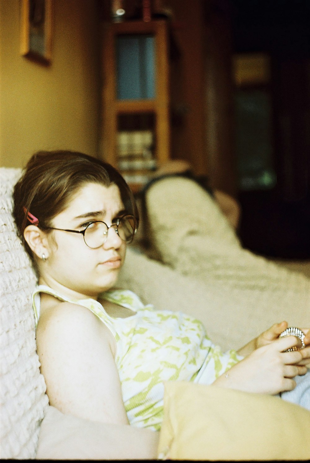 a woman sitting on a couch looking at a cell phone