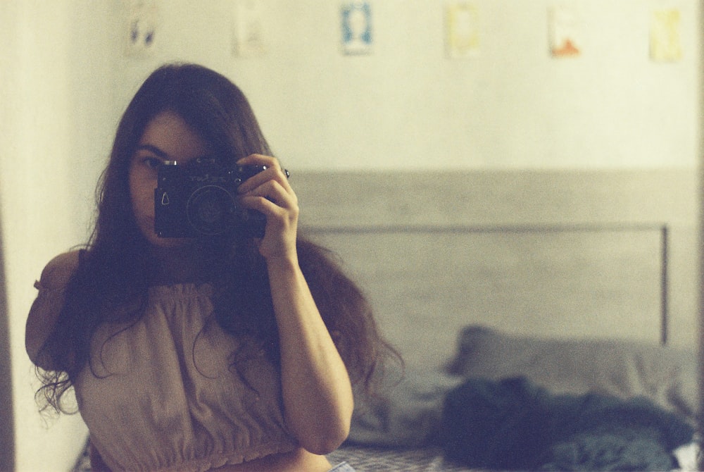 a woman taking a picture of herself in a mirror