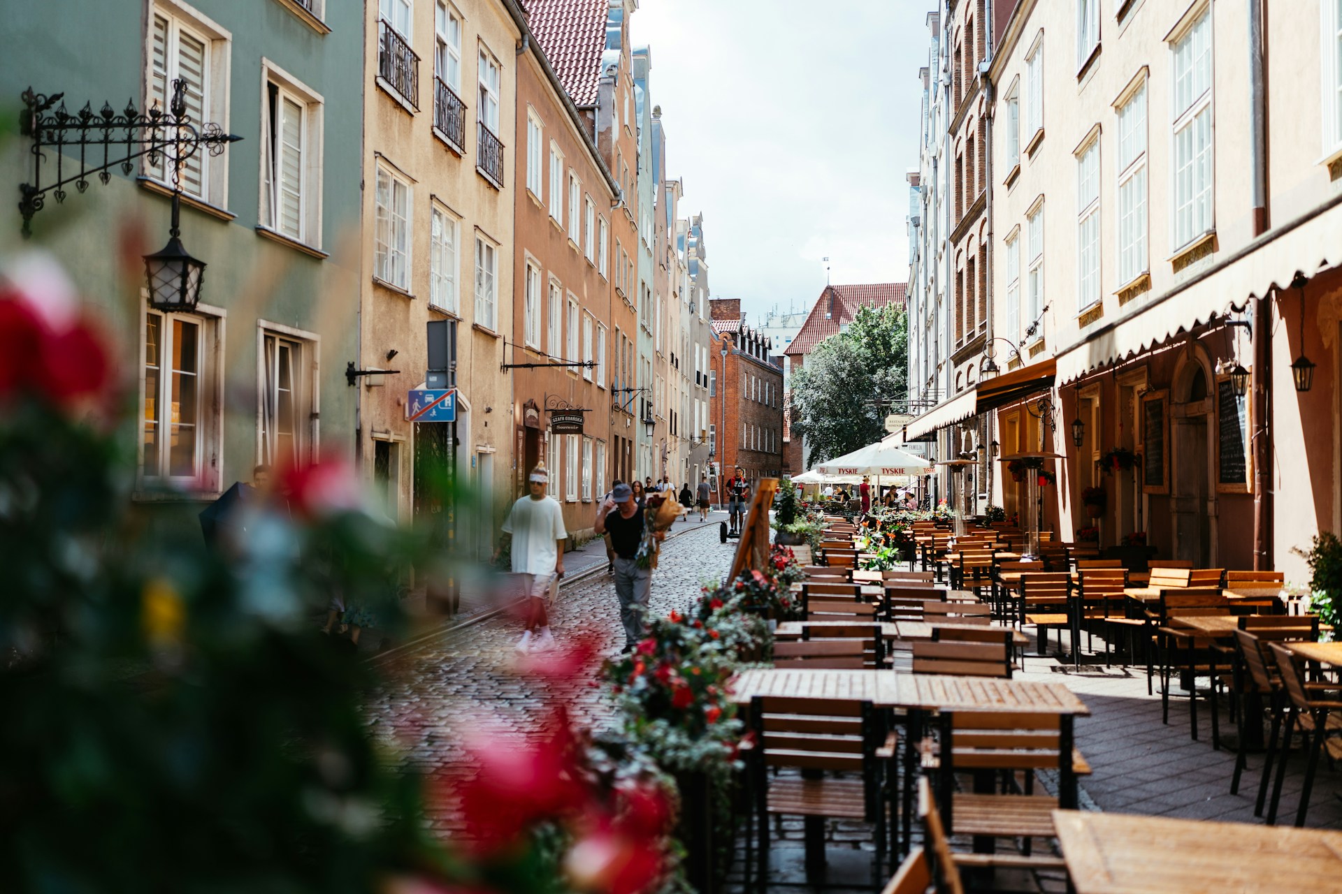 A charming cobblestone street in a historic European town, lined with colorful buildings and cozy cafes.