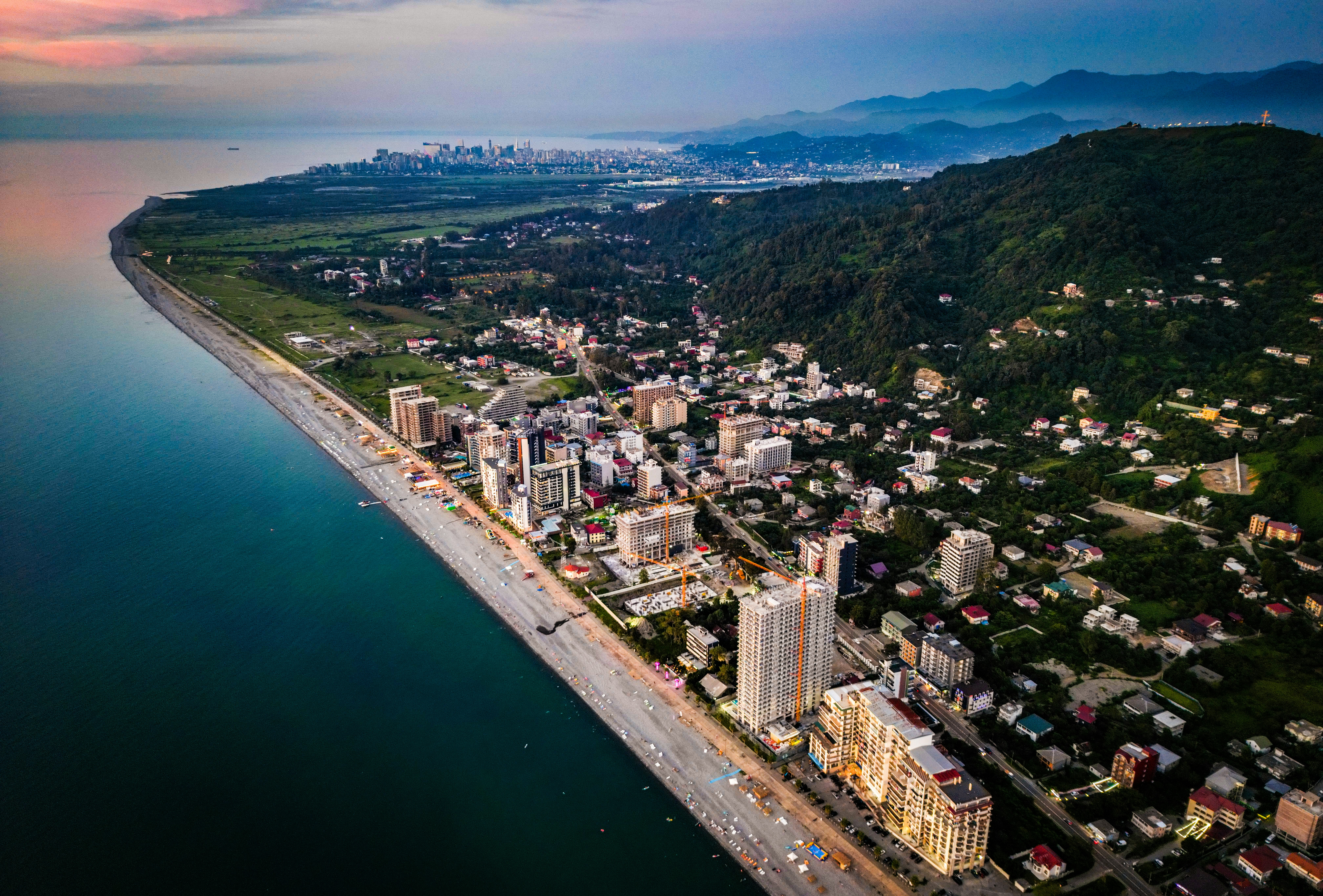 an aerial view of a city next to the ocean, 
