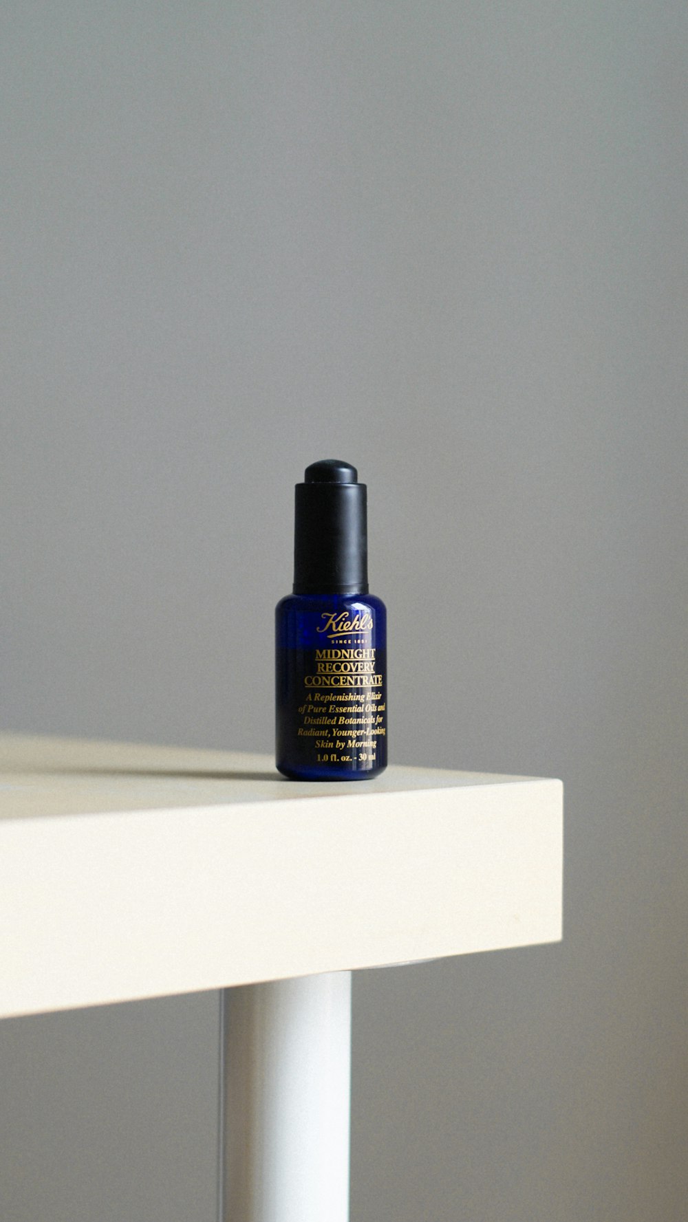 a bottle of blue liquid sitting on top of a white table