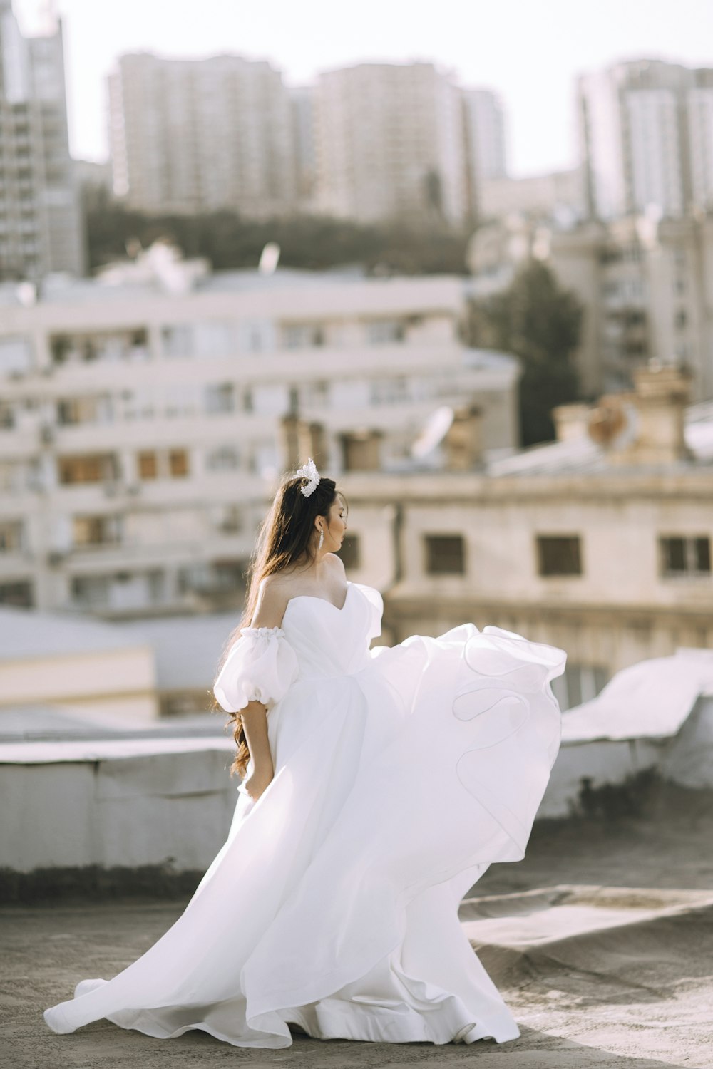 a woman in a white dress is standing on a roof