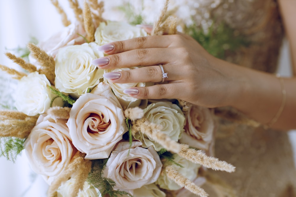 a close up of a person holding a bouquet of flowers