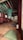 A traditional wooden interior with colorful ceiling beams, featuring intricate patterns and vibrant colors. The room contains several cushions on a polished wooden floor, suggesting a space for meditation or relaxation. Soft lighting filters through paper-covered windows, creating a serene and peaceful atmosphere.