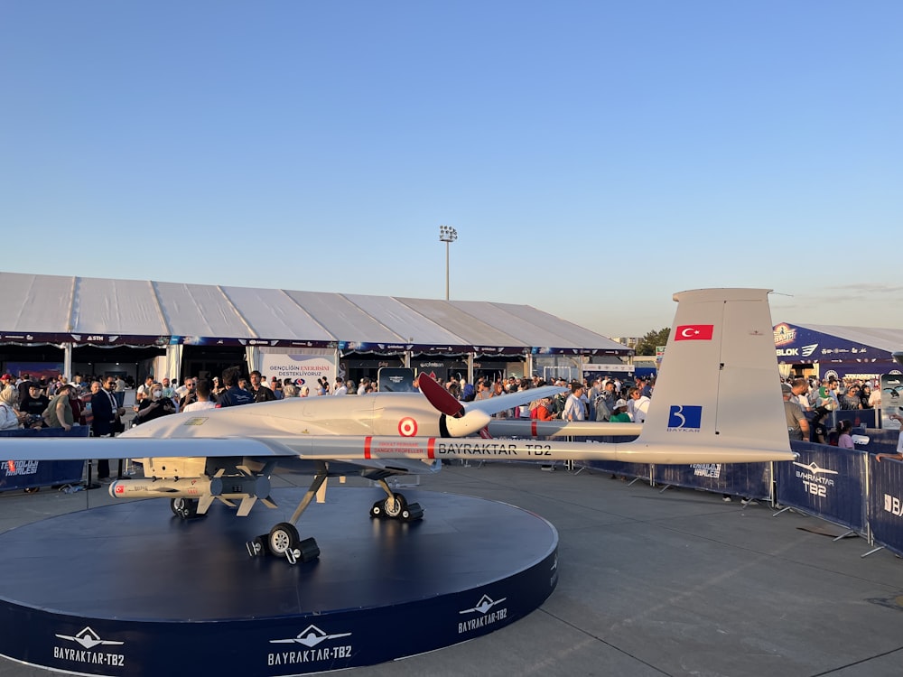 a crowd of people standing around a plane on display