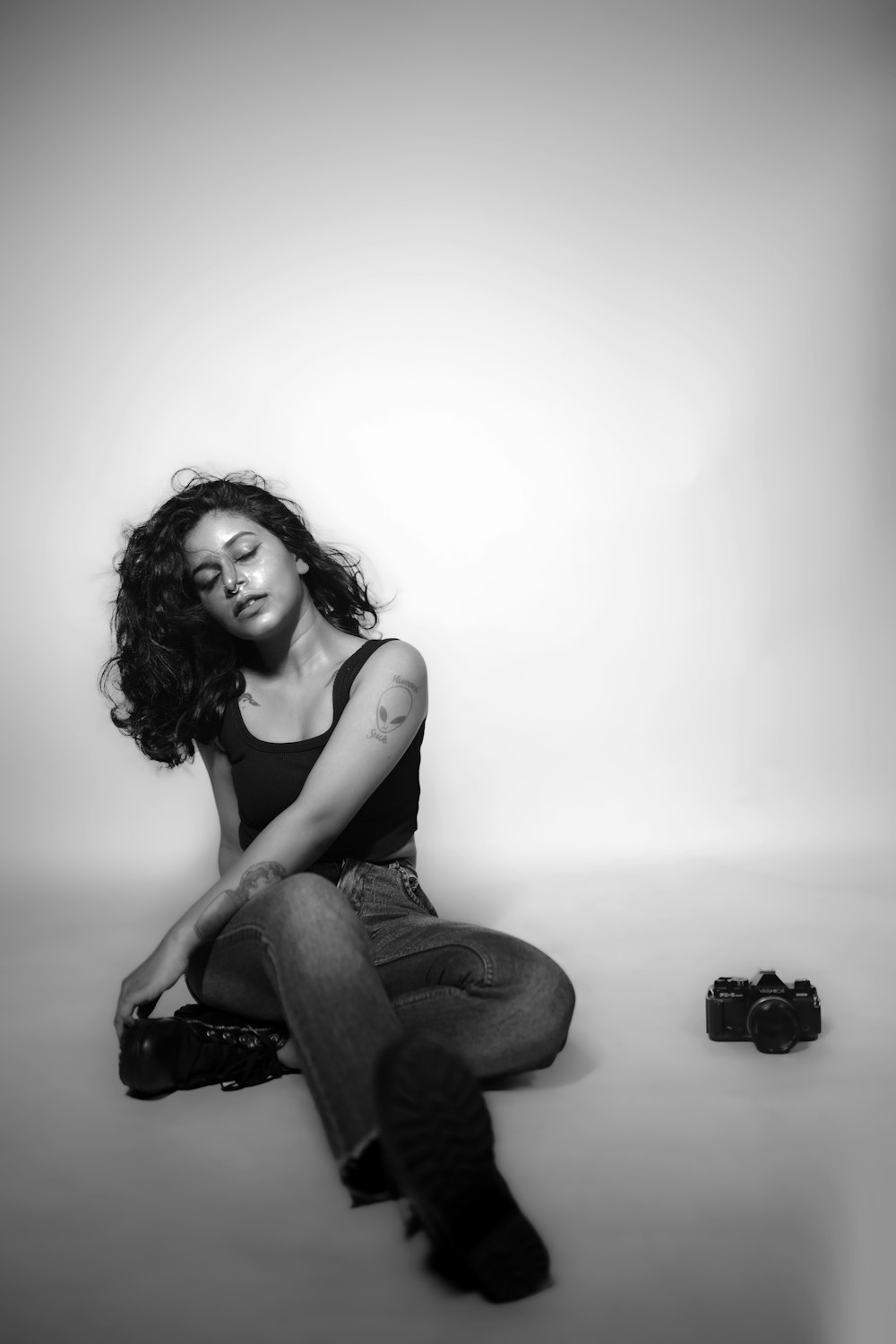 a black and white photo of a woman sitting on the ground