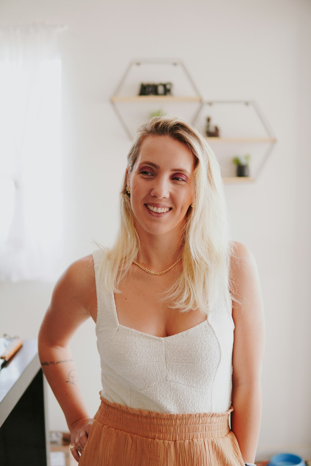 a woman standing in a kitchen with her hands on her hips