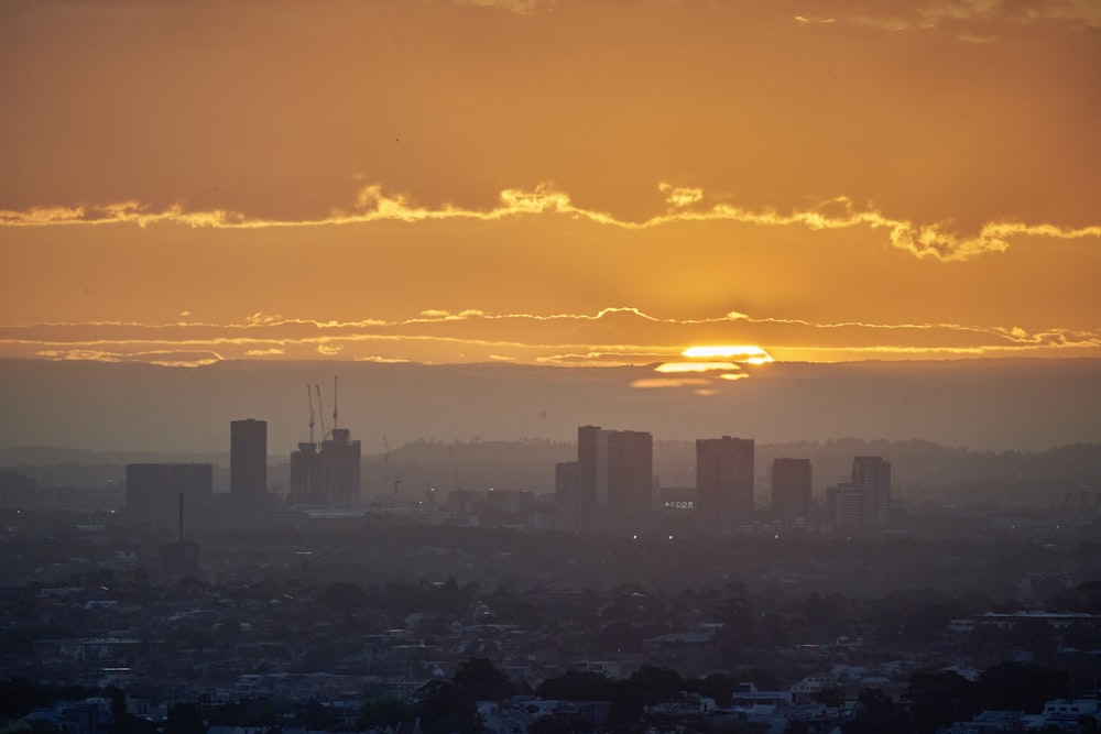 Il sole sta tramontando su una città con edifici alti