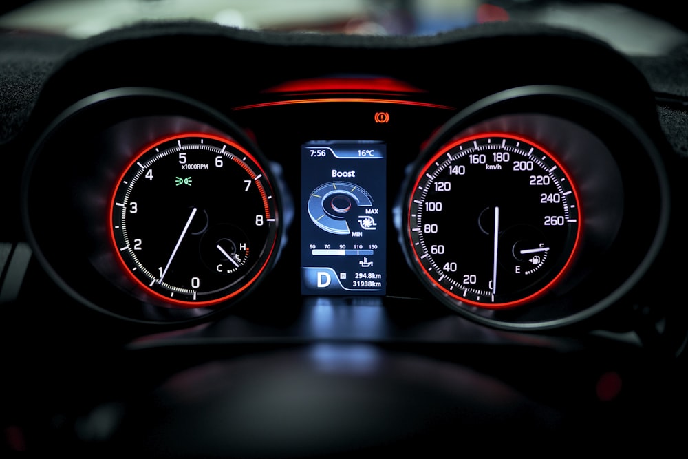 the dashboard of a car is lit up with red and white lights