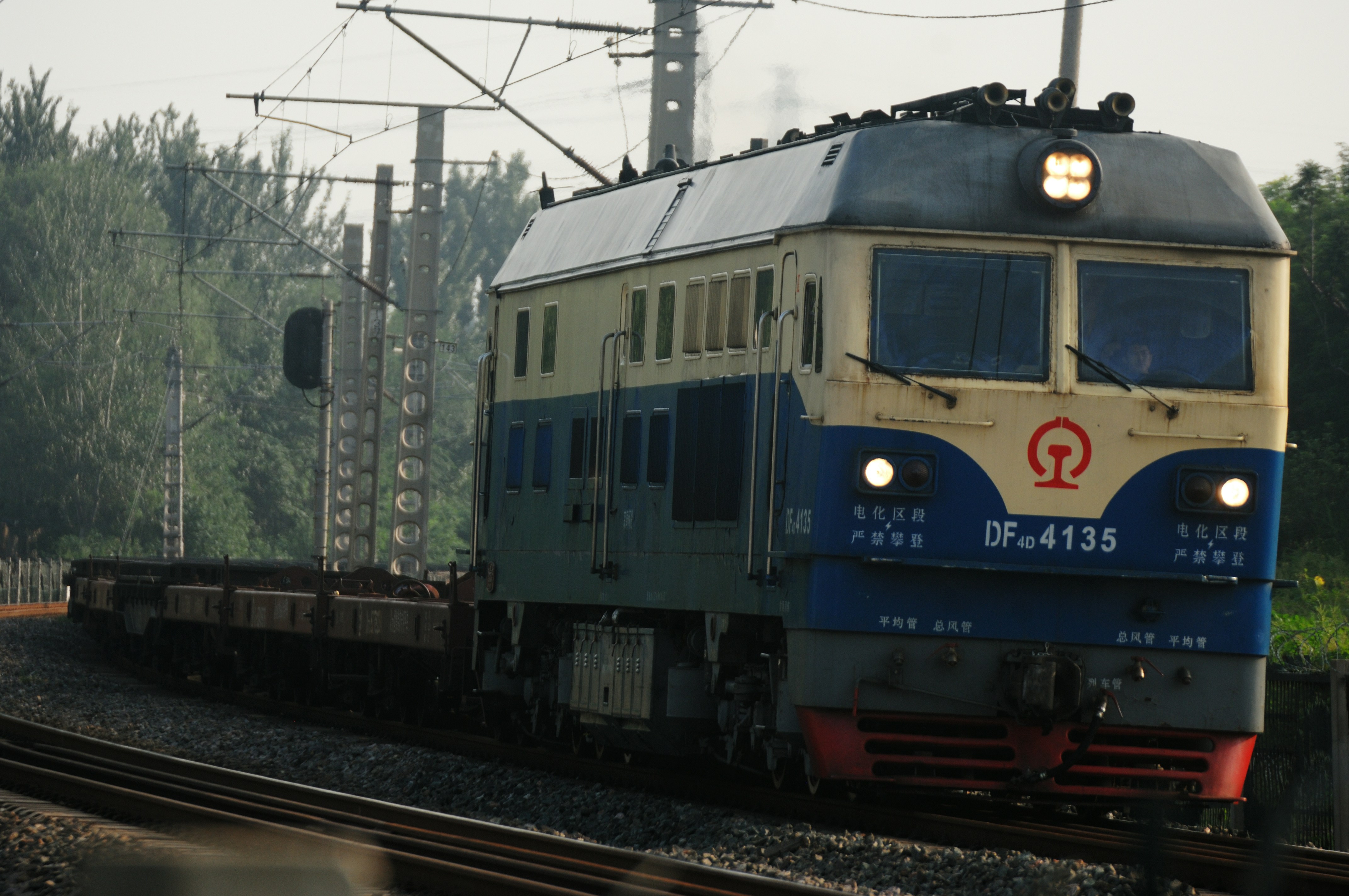 a blue and white train traveling down train tracks
