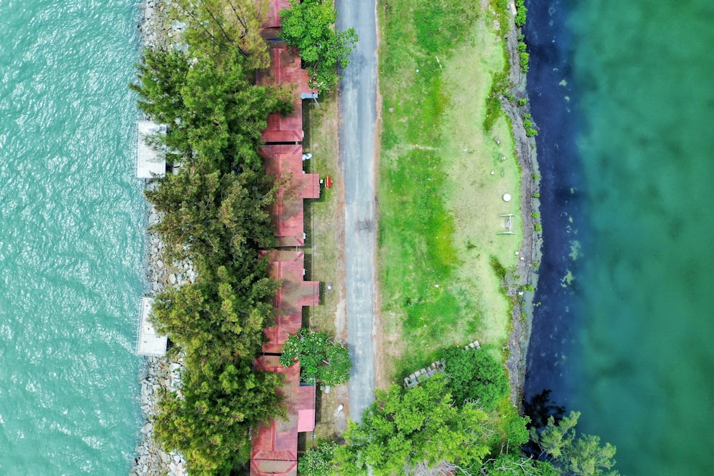 an aerial view of a road next to a body of water