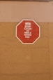 A red octagonal sign mounted on a tan-colored wall with the text 'KEEP CALM AND RENT A WICKED VAN' in white letters along with a white icon of a van at the top.