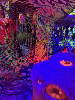 Wide cinematic view of a blurred playful room with abstract colorful blocks and floating toy rockets glowing softly.