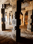 A close-up of textured stone carvings illuminated by soft, warm light highlighting intricate details.