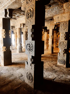 A close-up of textured stone carvings illuminated by soft, warm light highlighting intricate details.