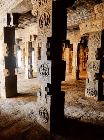 A close-up of textured stone carvings illuminated by soft, warm light highlighting intricate details.