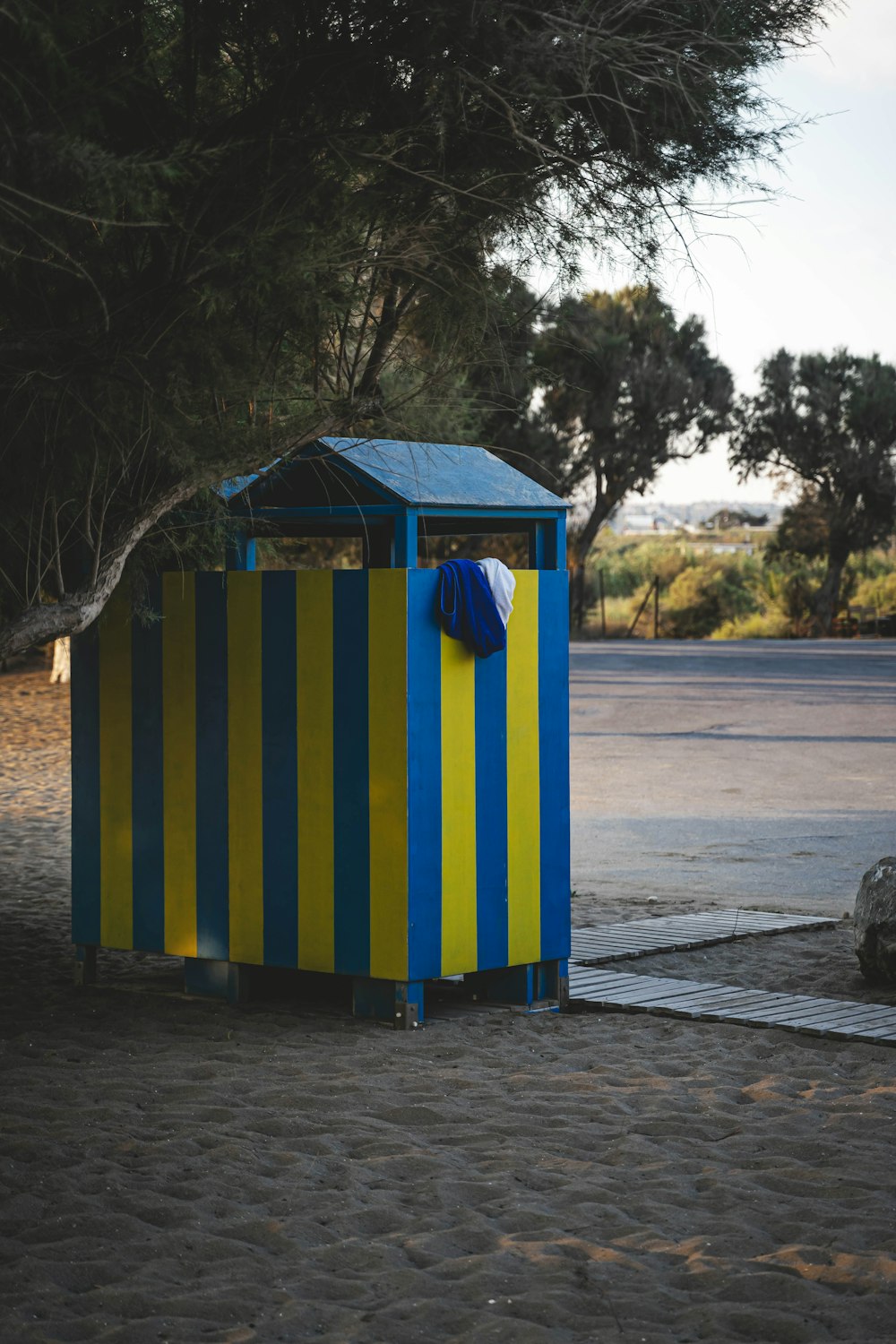 a small blue and yellow box sitting on the side of a road