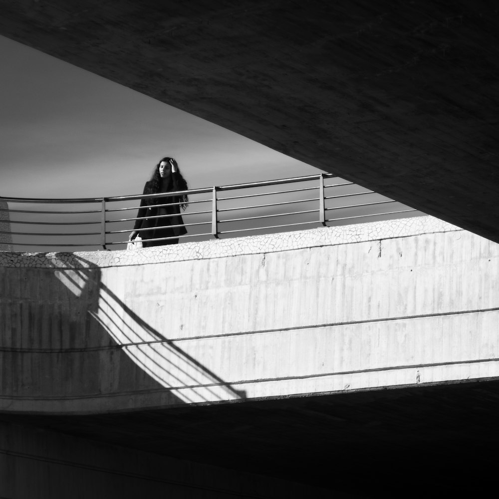 a person standing on a bridge with a skateboard