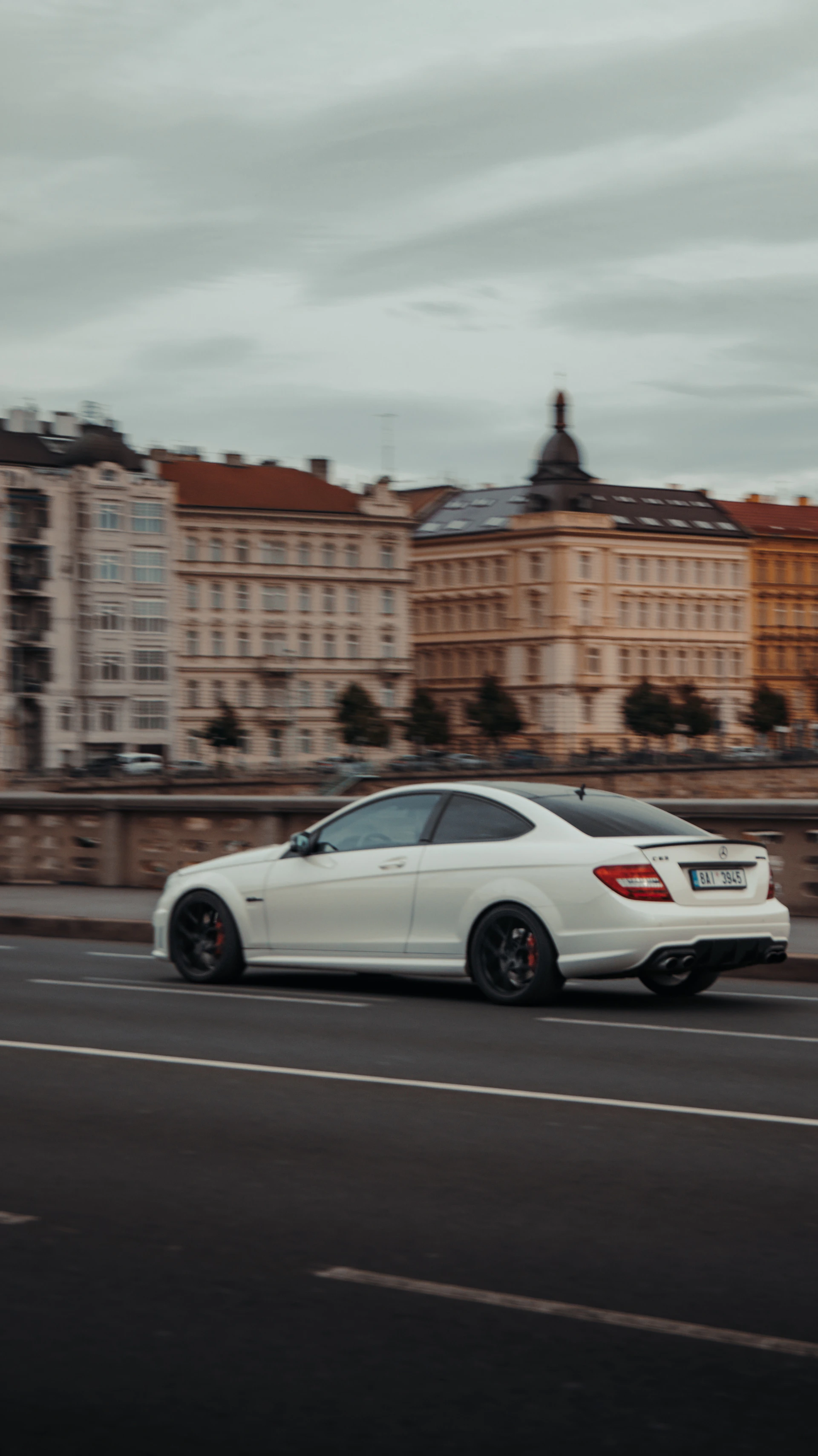 A high-speed police chase weaving through narrow European city streets at sunset.