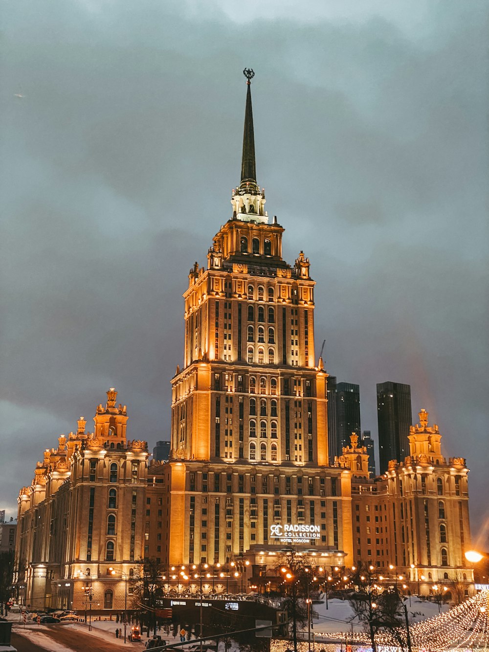 Un edificio muy alto con un campanario iluminado por la noche