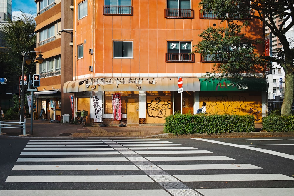 a crosswalk in front of a building with graffiti on it