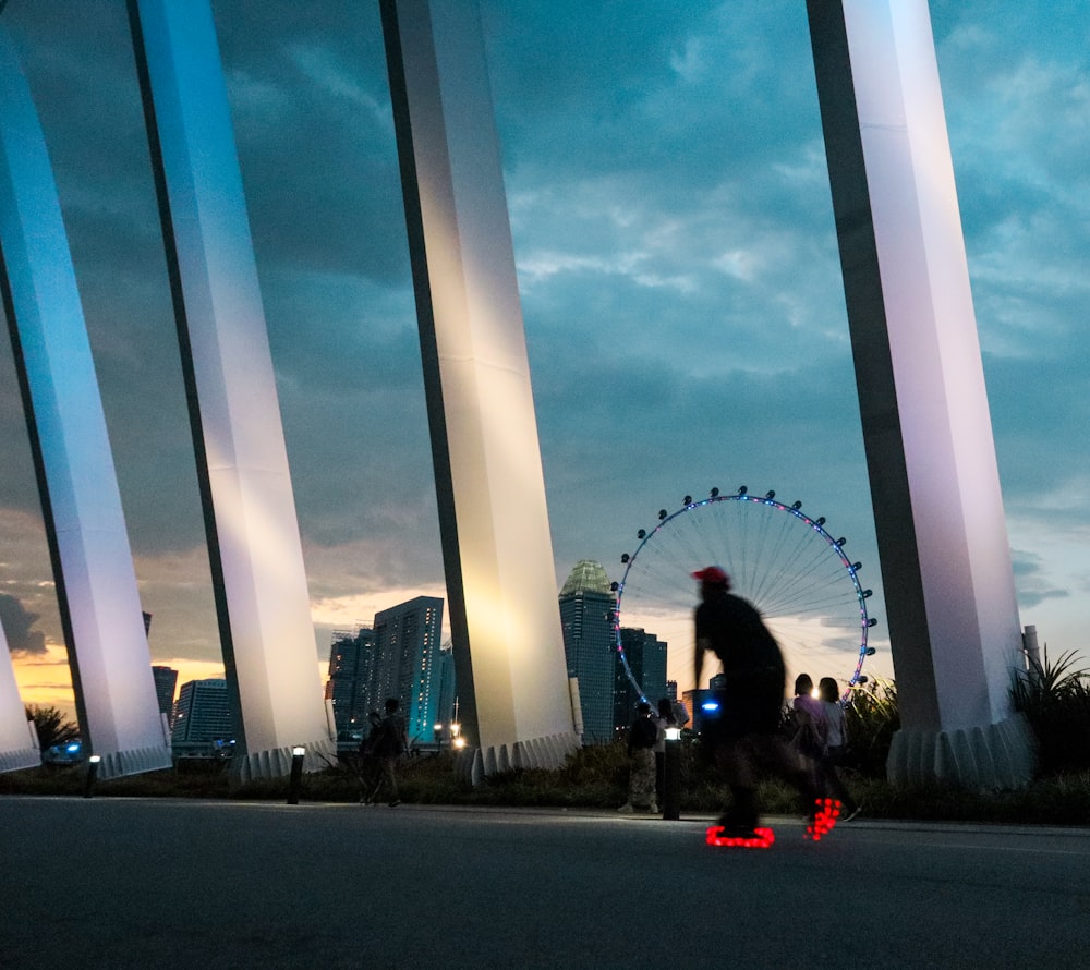 a man riding a skateboard down a street next to tall buildings