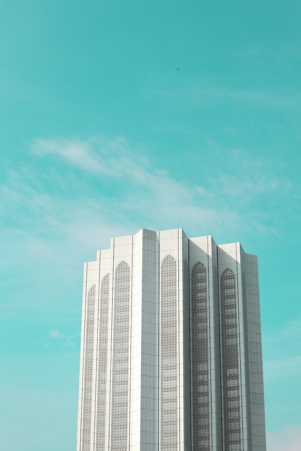 Un edificio alto y blanco con un fondo de cielo