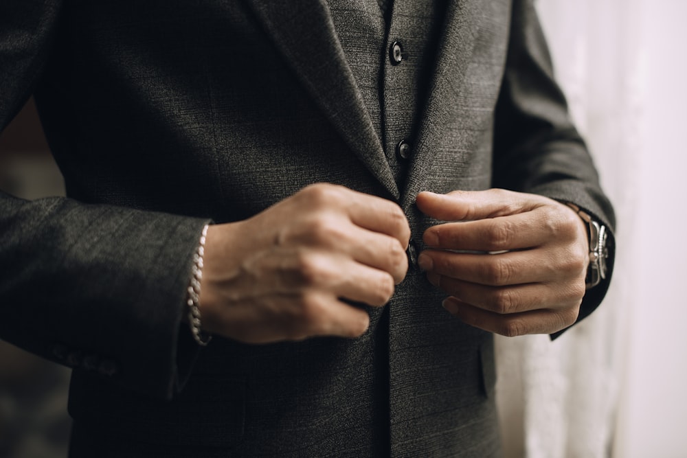 a man in a suit adjusting his watch